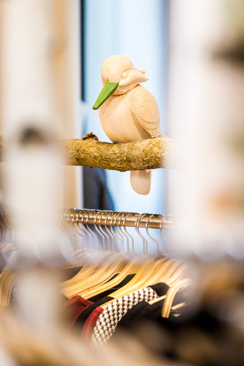 Vogel auf einem Ast sitzend als Detail im Bekleidungsgeschäft. Fotografiert von Jan Rieger.